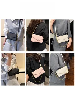 Detail of trendy small square bag showing lychee grain leather and gold chain strap