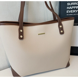 Dettaglio borsa tote in pelle martellata con finiture in metallo e cinturini