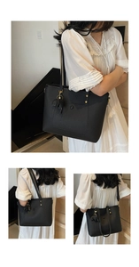 Detail of black pebbled leather tote bag with gold hardware and elephant charm decoration
