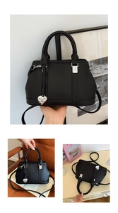 Detailed view of black lychee grain leather handbag with silver heart-shaped charm