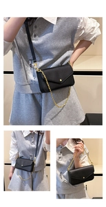 Detail view of black pebble leather envelope crossbody bag with gold chain and round buckle