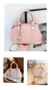 Macro shot of light pink lychee grain handbag with silver heart charm and crossbody strap