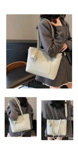 Detail of grey lychee leather tote bag with wide jacquard strap and leaf charm ornament