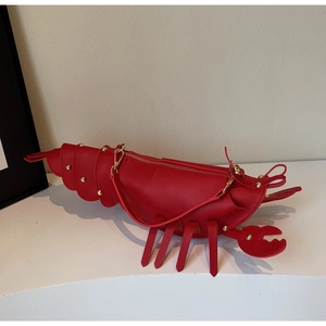 Detail view of red lobster shaped novelty bag with segment shell and gold rivets