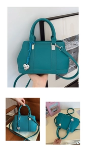 Detail of teal lychee grain handbag with silver heart charm and adjustable strap