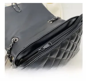 Detail shot of the black quilted leather bag interior featuring a smooth metal zipper