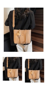 Detail of beige lychee pattern leather tote bag with a small elephant charm on the strap