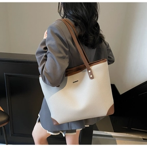 Dettaglio della borsa tote crema minimalista con finiture in pelle marrone scuro