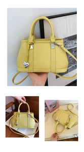 Close-up of yellow lychee grain leather handbag with silver heart charm and crossbody strap