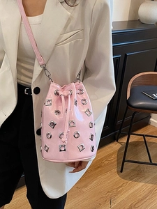 Pink metallic patent leather bucket bag with silver studs and drawstring closure