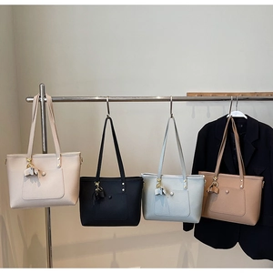 Litchi texture PU tote bags in four colors hanging on a minimalist display