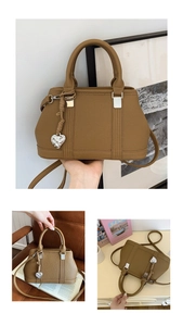 Detail of lychee pattern leather handbag with silver heart charm and adjustable strap