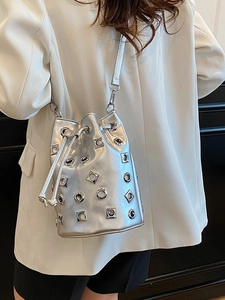 Modern metallic silver bucket bag with eyelet studs and drawstring closure