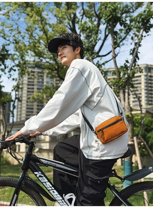 Orange nylon crossbody bag for cycling with sleek black metal zipper and compact design