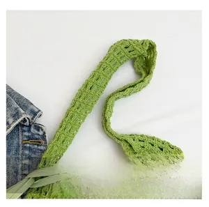 Detail of the green woven cotton shoulder bag featuring hollow crochet craftsmanship and a soft handle