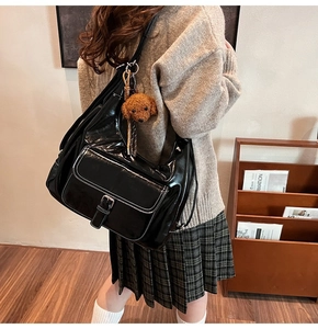 Glossy black oil wax leather shoulder bag with buckle pocket and brown plush dog pendant