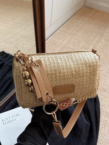 Cylindrical straw woven shoulder bag with brown leather trim and golden chain strap