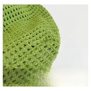 Detailed macro shot of green hollow out crochet knit fabric for a summer beach bag