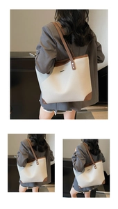 Dettaglio di una grande borsa tote beige con manici marroni abbinata a un abito grigio
