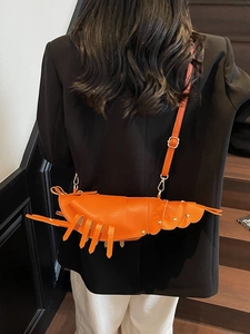 Vibrant orange lobster-shaped crossbody bag with metal rivets and adjustable strap