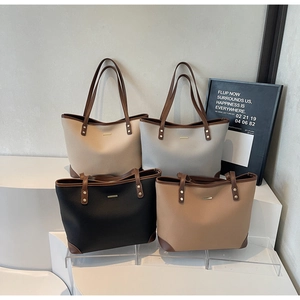 Quattro grandi borse tote in beige, grigio, nero e marrone con rivetti in metallo