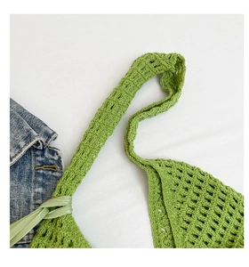 Detalle de bolso playero de ganchillo verde con diseño calado y cordones laterales