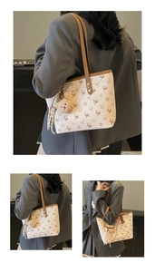 Detail of deer pattern tote bag with bear charm and red tassel on leather strap