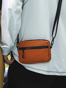 Orange nylon crossbody bag for women with dual black zippers and adjustable strap
