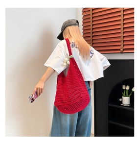Detalle de bolso hobo de ganchillo rojo con colgante de tulipán para las vacaciones