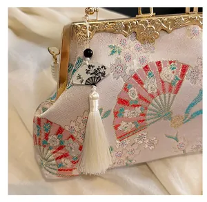 Detail of Chinese style shell bag with floral embroidery and silk tassel charm