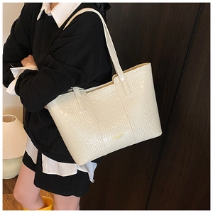 Détail du sac cabas blanc cassé avec cuir embossé crocodile et logo de marque doré
