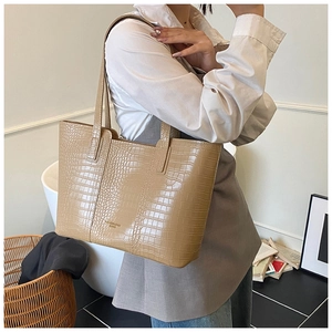 Gros plan du sac cabas kaki motif crocodile avec lettrage doré et doubles poignées de luxe