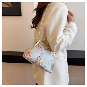 Detail of embroidered floral silk bag with pearl chain and golden metal clasp