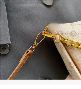 Close-up of golden hardware and vintage printed monogram on the crescent shoulder bag