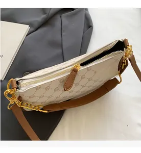 Detailed close-up of smooth gold zipper and vintage pattern on shoulder bag