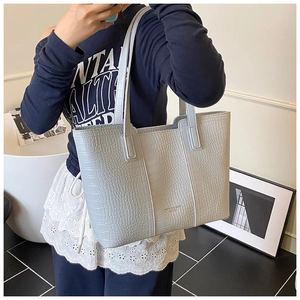 Vue détaillée du sac cabas gris bleu clair avec motif crocodile et logo doré
