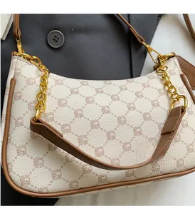 Macro shot of retro monogram crescent bag with gold chain and leather shoulder strap