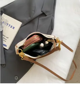 Detail of the interior storage capacity showing daily items in the canvas crossbody bag