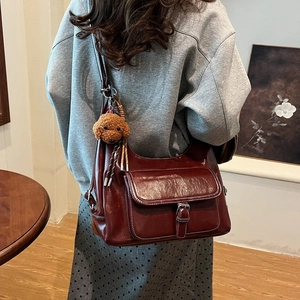 Deep red oily leather shoulder bag with vintage buckle and cute brown teddy bear charm