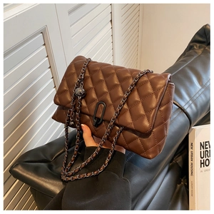 Detail of dark brown quilted leather crossbody bag with adjustable metal chain strap