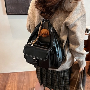 Chic black oil wax leather shoulder bag with vintage metal buckle and plush bear charm