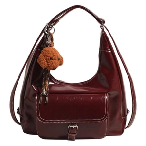 Deep red vintage oil wax leather shoulder bag with white stitching and teddy bear charm