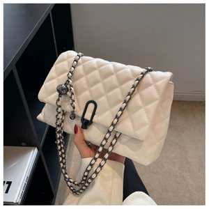 Detail of quilted leather texture and adjustable metal ball chain on ivory crossbody bag