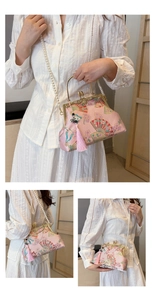 Detailed view of pink Chinese style jacquard clutch with pearl strap and fringe