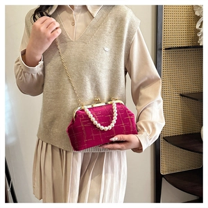 Détail du sac coquille en velours avec poignée en perles et bandoulière chaîne dorée