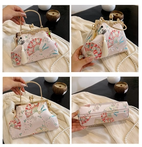Detail of pink qipao clutch featuring plum blossom embroidery and metal ring handle
