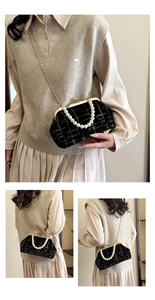 Détail du sac coquille en velours avec poignée en perles et bandoulière dorée