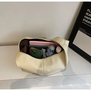 Vue de dessus d'un grand sac fourre-tout crème avec tablette, téléphone et objets usuels