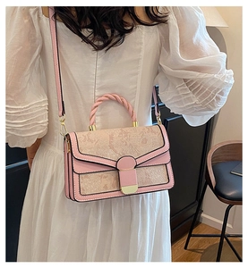 Close-up of vintage floral embroidery and pink leather stitching on shoulder bag