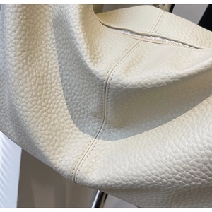 Détail du sac cabas crème texturé avec coutures fines et fermeture éclair